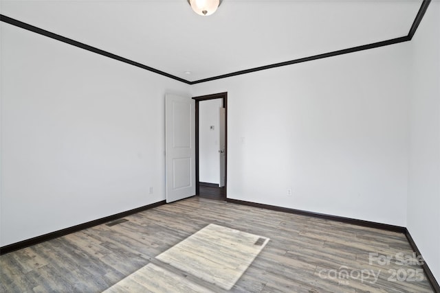 spare room with crown molding and wood-type flooring