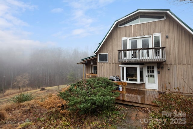 rear view of property featuring a wooden deck