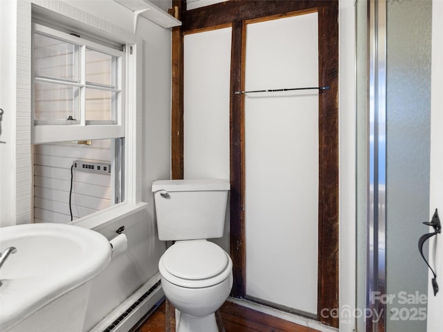 bathroom with a baseboard heating unit, sink, and toilet