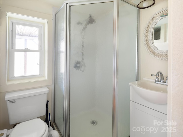 bathroom featuring walk in shower, vanity, and toilet