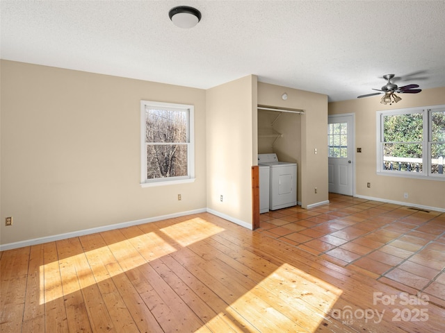 unfurnished living room with washing machine and clothes dryer, light hardwood / wood-style flooring, and a textured ceiling