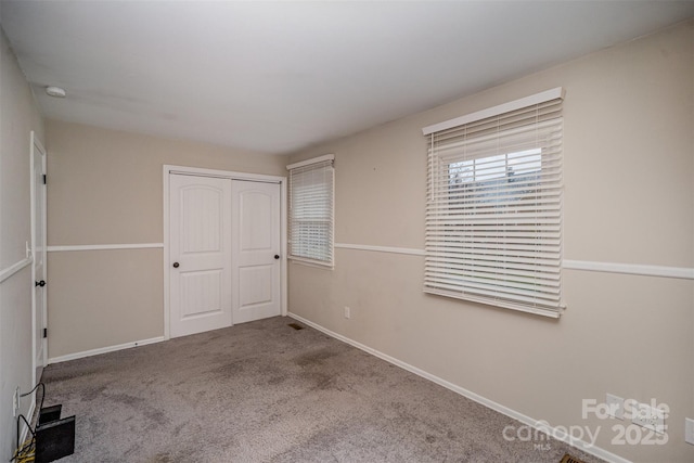 unfurnished bedroom with carpet flooring and a closet