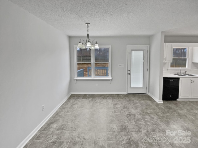 unfurnished dining area featuring sink, a notable chandelier, and a textured ceiling