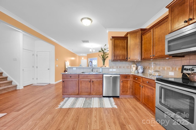 kitchen with tasteful backsplash, stainless steel appliances, light hardwood / wood-style floors, and sink