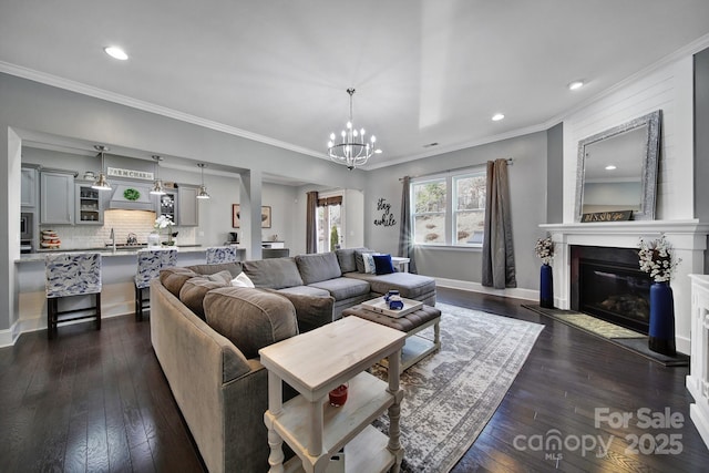 living area with a large fireplace, crown molding, baseboards, and dark wood-type flooring