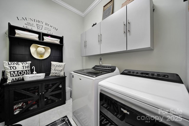 laundry room featuring ornamental molding, light tile patterned flooring, washing machine and dryer, and cabinet space