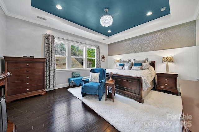 bedroom featuring a raised ceiling, visible vents, dark wood-style flooring, and wallpapered walls