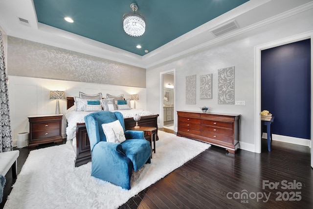 bedroom featuring baseboards, a tray ceiling, visible vents, and dark wood-style flooring