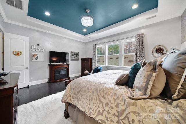 bedroom featuring a raised ceiling, visible vents, and baseboards