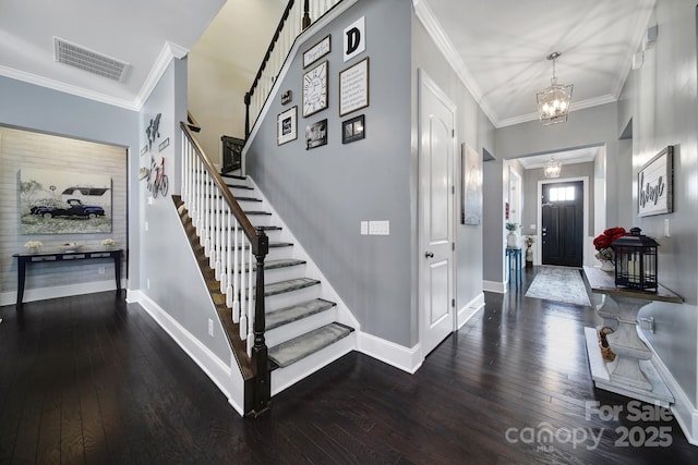 entrance foyer with dark wood finished floors, visible vents, crown molding, and baseboards