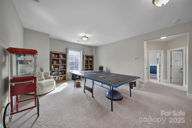 game room featuring baseboards and light colored carpet