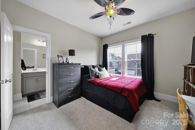 bedroom featuring ceiling fan, connected bathroom, light colored carpet, visible vents, and baseboards