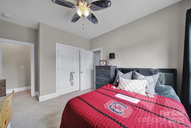 bedroom with light carpet, ceiling fan, a closet, and baseboards