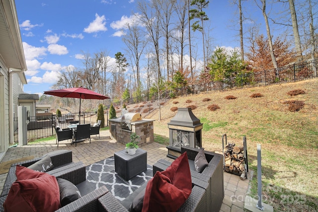 view of patio with an outdoor living space with a fireplace, grilling area, and a fenced backyard