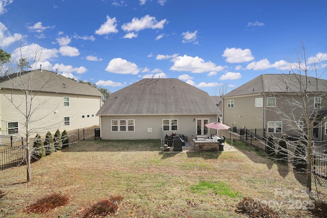 rear view of house with a yard, a fenced backyard, a patio, and a shingled roof