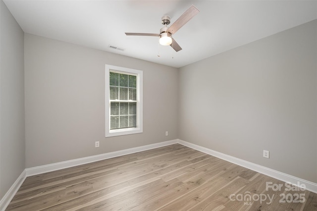 empty room featuring baseboards, a ceiling fan, light wood finished floors, and visible vents