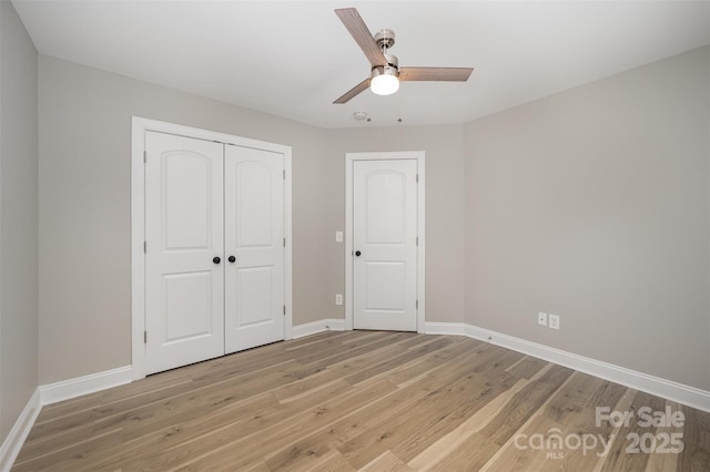 unfurnished bedroom with light wood-style floors, a ceiling fan, baseboards, and a closet
