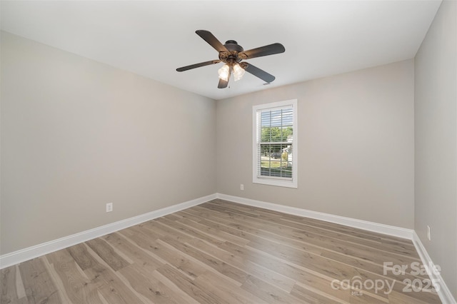 empty room with baseboards, ceiling fan, and light wood-style flooring