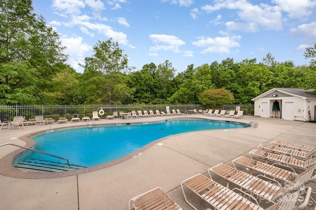 community pool with a patio and fence