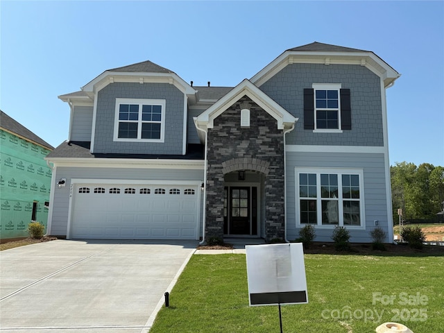 view of front of property featuring a garage, a front lawn, driveway, and stone siding