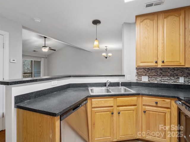 kitchen featuring stainless steel appliances, dark countertops, a sink, and visible vents