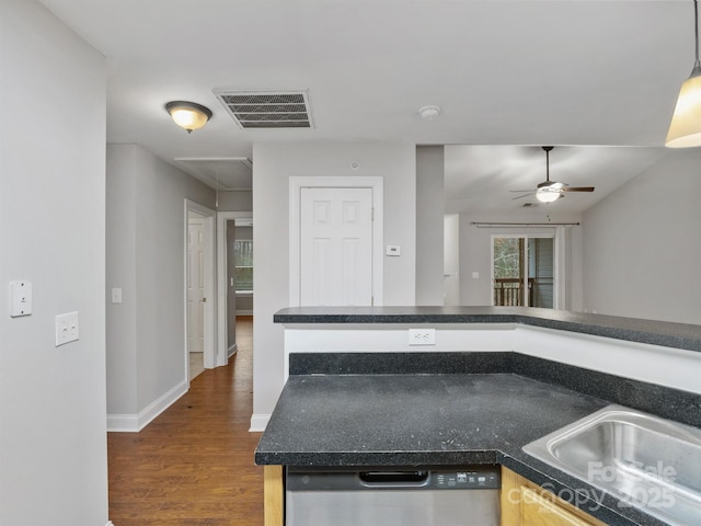 kitchen featuring dark countertops, visible vents, a sink, wood finished floors, and dishwasher