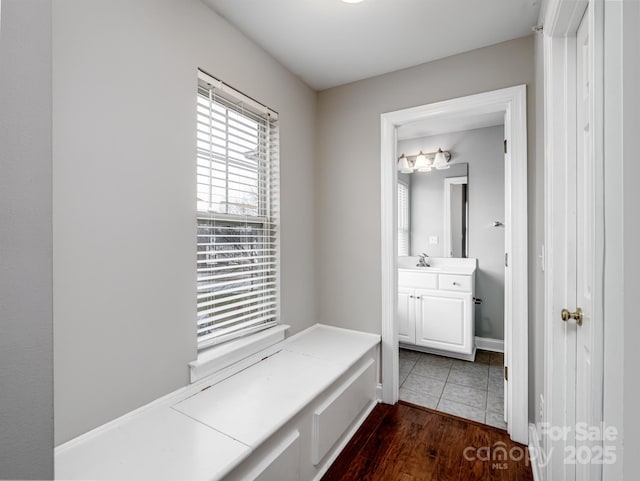 bathroom featuring wood finished floors, vanity, and baseboards