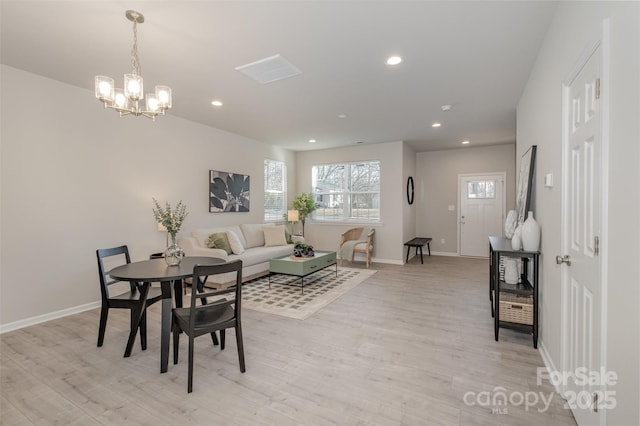 dining space with a notable chandelier and light hardwood / wood-style flooring