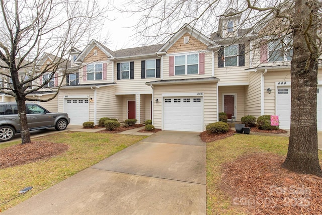 townhome / multi-family property featuring a garage and a front lawn