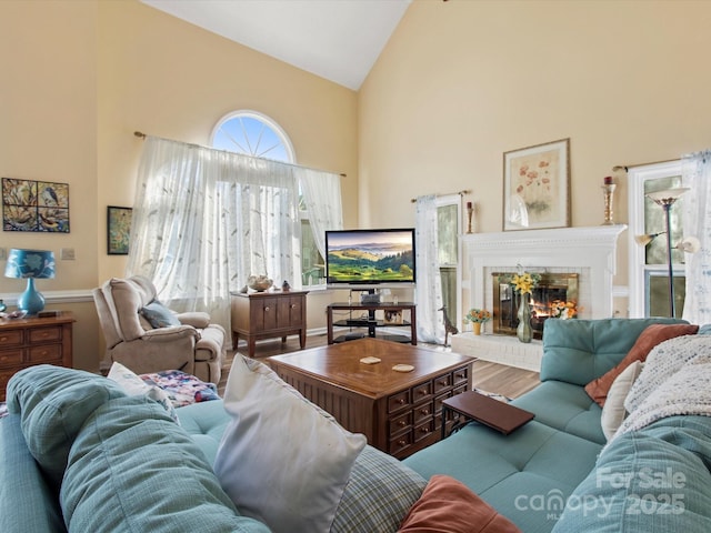 living room with a brick fireplace and high vaulted ceiling