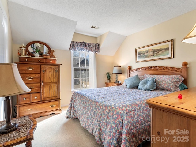 bedroom with carpet flooring, vaulted ceiling, and a textured ceiling