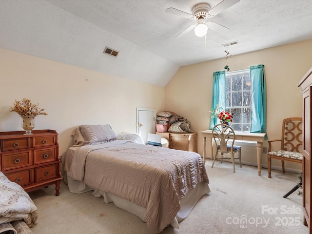 carpeted bedroom featuring ceiling fan, vaulted ceiling, and a textured ceiling