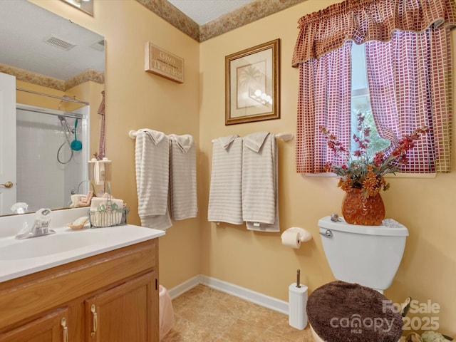 bathroom featuring vanity, a textured ceiling, toilet, and walk in shower