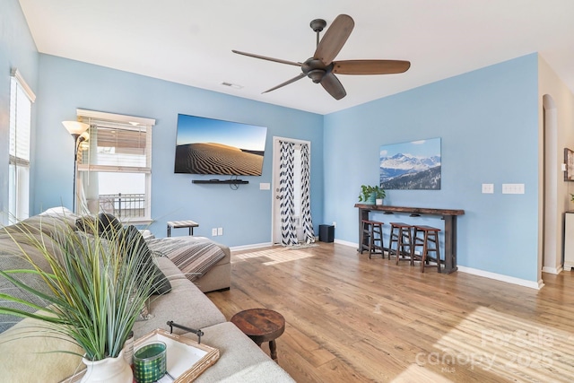 living room with ceiling fan and light wood-type flooring