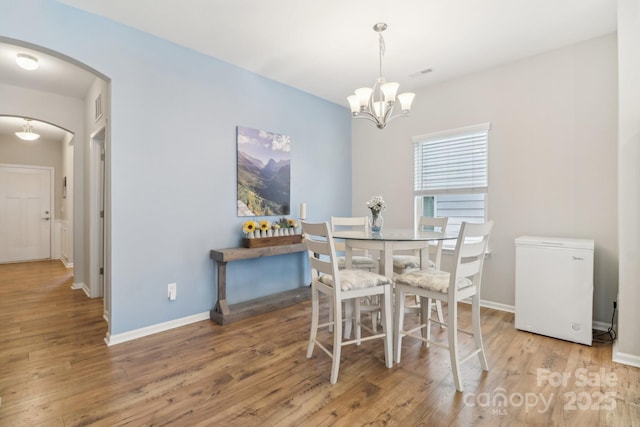 dining area with a notable chandelier and light wood-type flooring