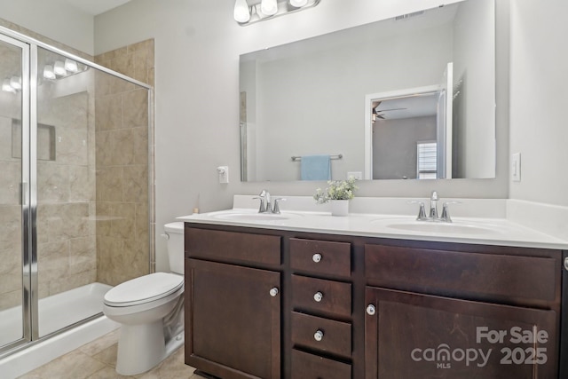 bathroom with toilet, a shower with shower door, vanity, ceiling fan, and tile patterned flooring