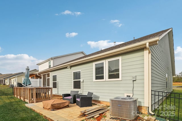 back of house with central AC, a yard, a deck, and a patio