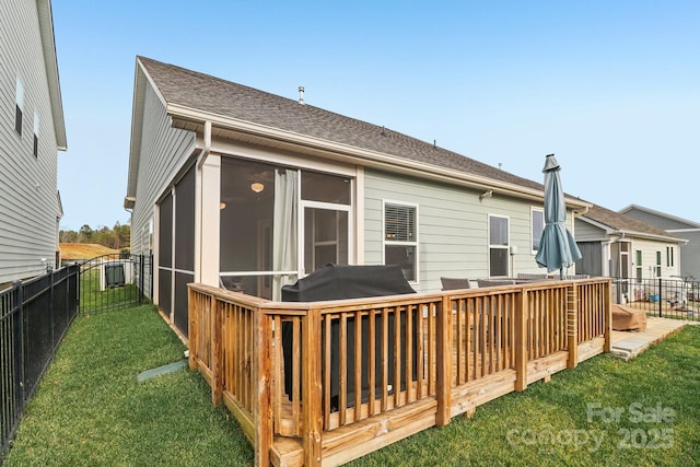 back of property featuring a sunroom, a deck, and a lawn