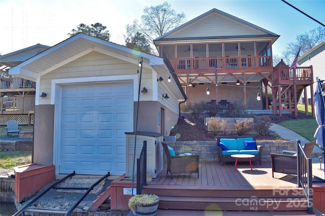 back of property with an outbuilding, stairway, a sunroom, a wooden deck, and an outdoor hangout area