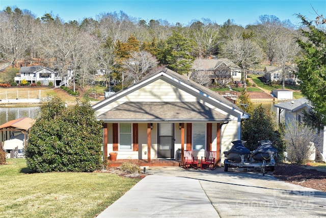 bungalow with a front lawn, covered porch, and a shingled roof