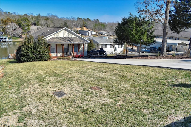 view of front of property with a front yard, covered porch, and a water view