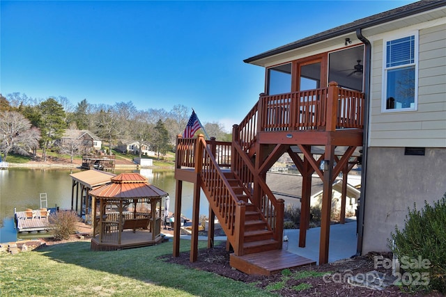 view of playground featuring a gazebo, stairs, a deck with water view, and a yard