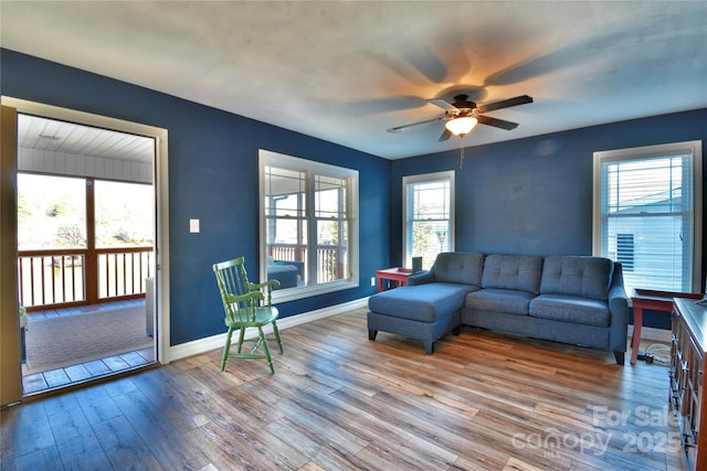 living room with ceiling fan, baseboards, a healthy amount of sunlight, and wood finished floors