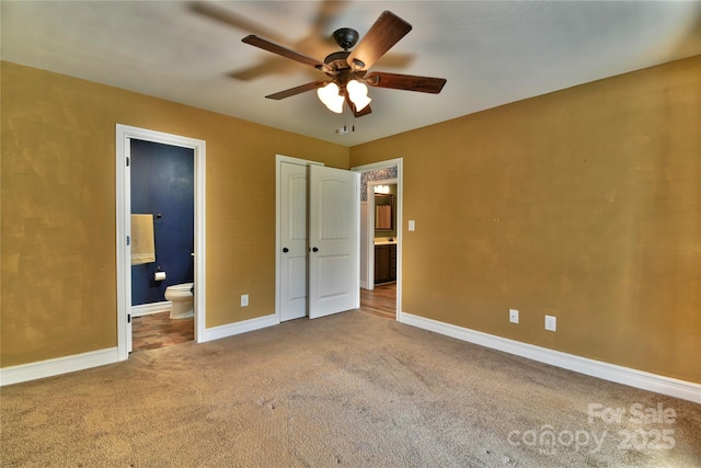 unfurnished bedroom with baseboards, carpet, ceiling fan, and ensuite bathroom