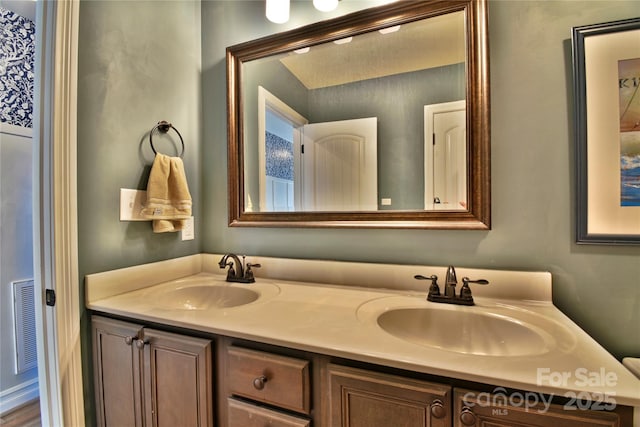 full bathroom with double vanity, visible vents, and a sink