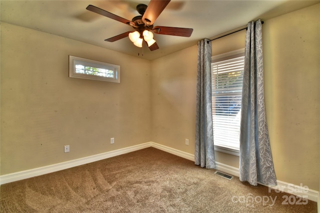 carpeted spare room with visible vents, ceiling fan, and baseboards