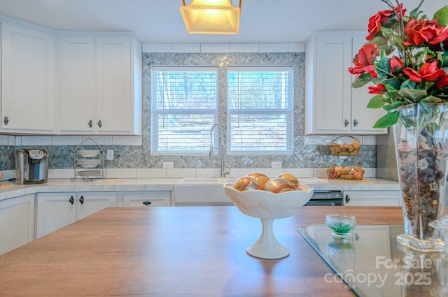 kitchen featuring white cabinetry, sink, and decorative backsplash