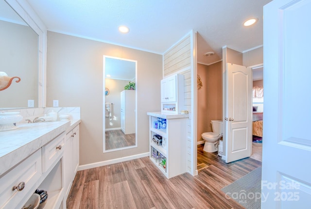 bathroom featuring vanity, hardwood / wood-style flooring, crown molding, and toilet