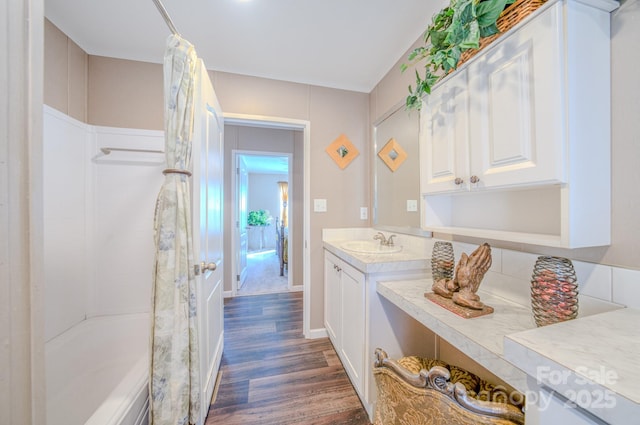 bathroom featuring hardwood / wood-style flooring, vanity, and shower / bath combo