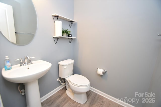 bathroom with sink, hardwood / wood-style floors, and toilet